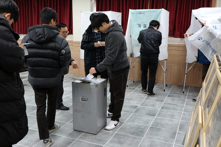 차례로 줄을 서서 기표를 마치고 투표함에 투표지를 투입하는 학생들의 모습