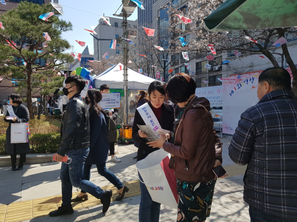 직원들이 축제방문객에게 리플릿과 홍보용품을 배부하면서 캠페인 하고 있는 장면
