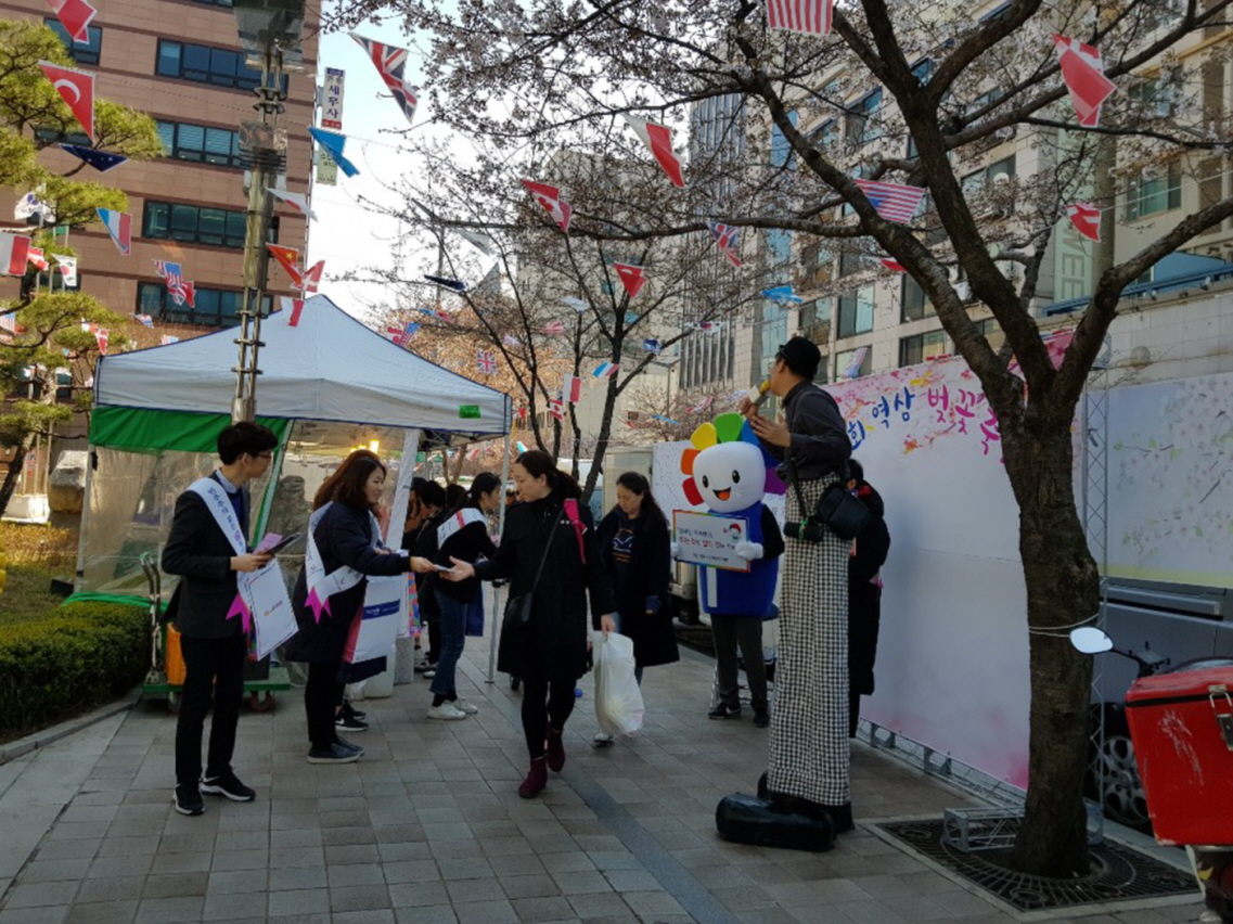 직원들이 축제방문객들에게 리플릿과 홍보용품을 배부하고 있는 장면