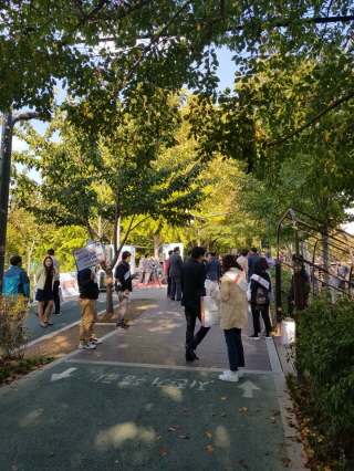 강남구선거관리위원회 직원들이 양재천 산책로에서 축제방문객들에게 리플릿과 홍보용품을 배부하는 장면