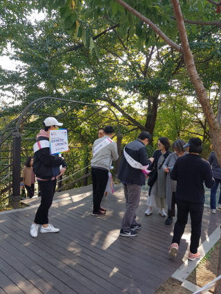 강남구선거관리위원회 직원들이 양재천 산책로에서 축제방문객에게 리플릿과 홍보용품을 배부하는 장면