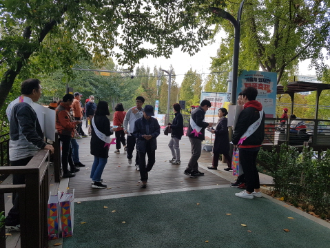 강남구선거관리위원회 직원들이 양재천 산책로에서 축제방문객에게 리플릿과 홍보용품을 배부하는 장면