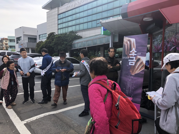 오일장에서 정치후원금 및 기부행위 상시제한 홍보를 하며 용품을 나눠주는 사진입니다.