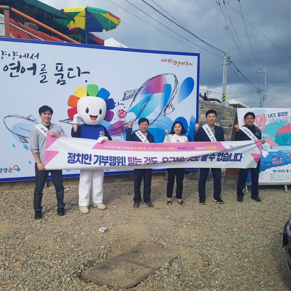 직원 등이 양양연어축제 행사장에서 기부행위 상시제한 홍보 현수막을 이용하여 홍보활동 하는 모습