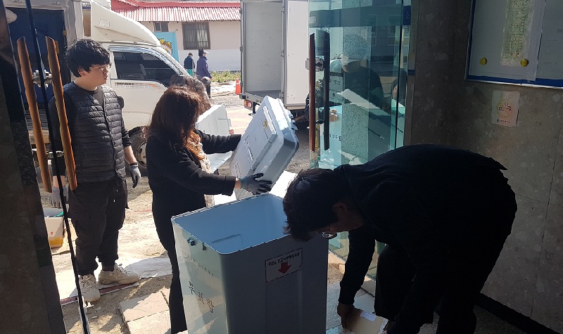 (사진1) 양양군위원회 사무과장 및 직원 등이 투표함에 투표용지를 담고 있다