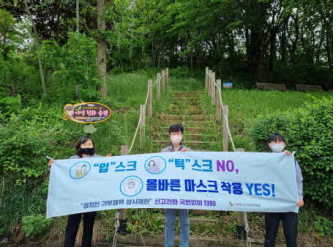 코로나19예방현수막을 든 직원들 홍보사진