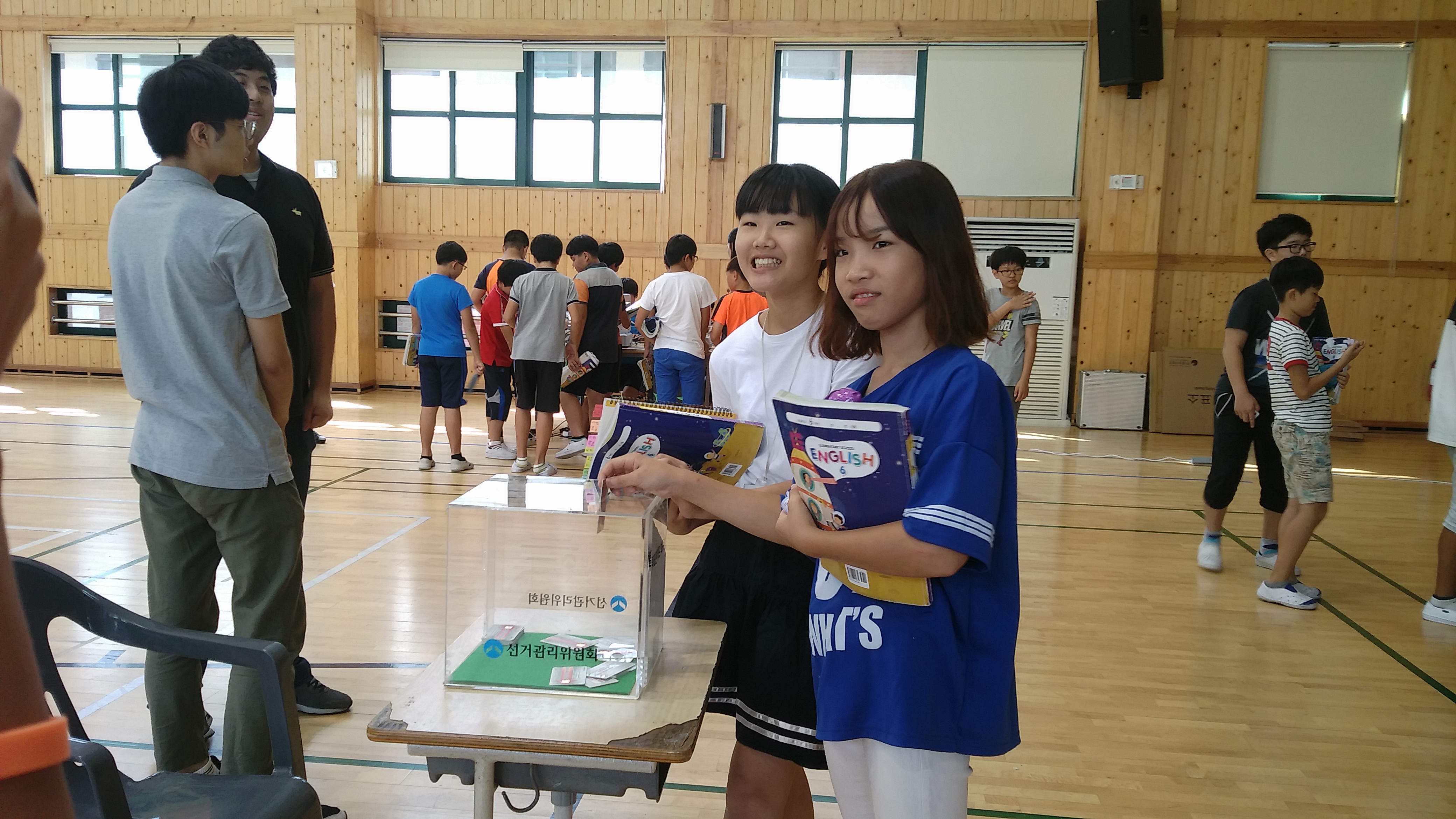 투표를 마치고 선거권 카드를 회수함에 넣고 있는 두 여학생의 모습