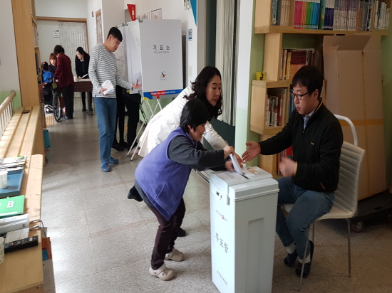교남시냇가 발달장애인이 투표하는 모습의 사진