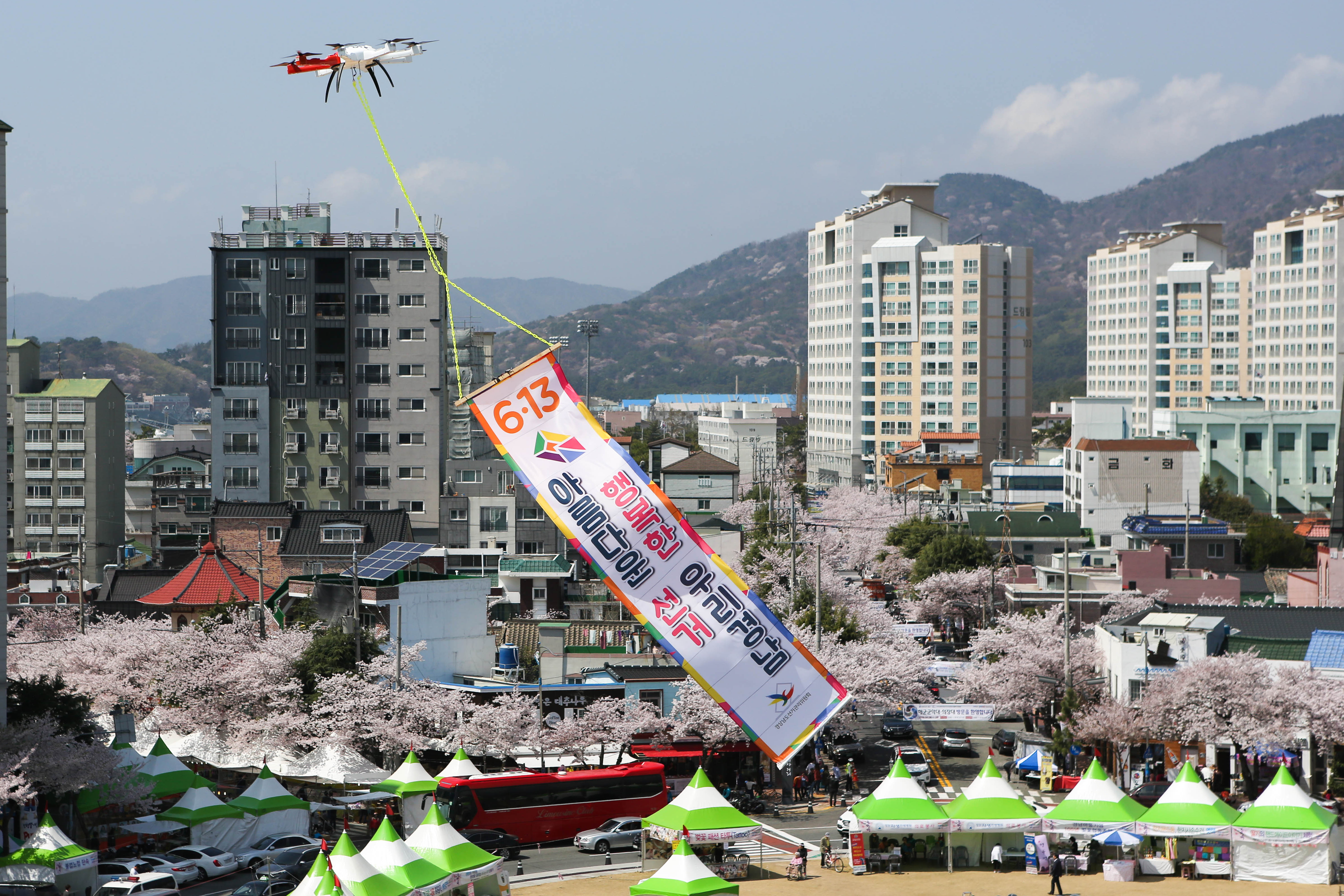 경남선관위가 진해 벚꽃축제 현장에서 드론을 이용하여 현수막 홍보를 하고 있는 모습이다.