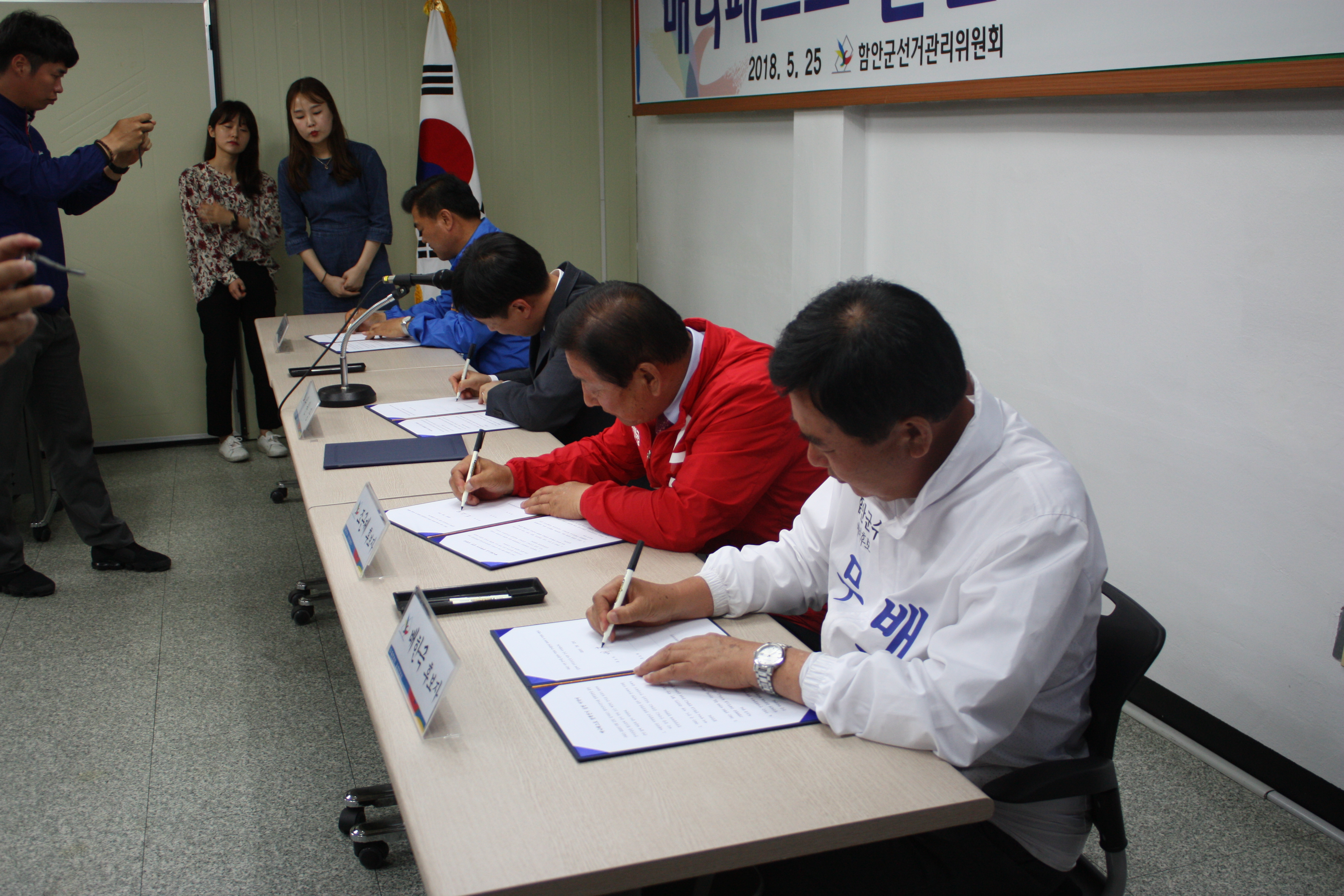 후보자들이 매니페스토 실천 서약서에 서명하는 모습