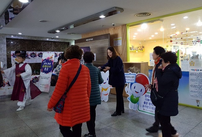 '종로구선거관리위원회 직원이 '시니어 슈퍼스타 종로' 행사장 방문객에게 리플릿 등 홍보물을 나눠주는 모습